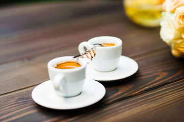 Two cups of coffee on a wooden