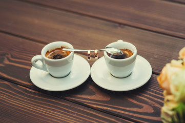 Two cups of coffee on a wooden