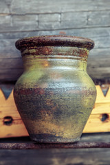 Old clay jug on wooden