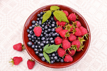 Raspberries , blueberries on ceramic plate.top view