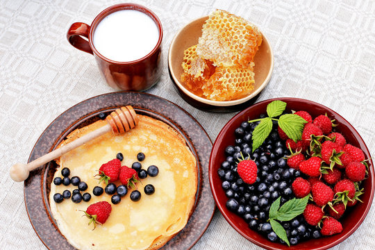 Pancakes  with raspberries, blueberries, milk, honeycomb