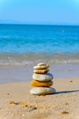 Fototapeta na wymiar Tower of stones on a tranquil beach