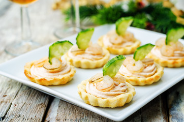 Obraz na płótnie Canvas tartlets with salmon mousse, shrimp and cucumber for the New yea