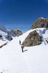 Fototapeta na wymiar Snowboarders walking uphill for freeride