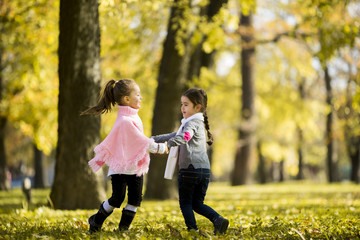 Two little girls at the autumn park