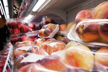 Packeged fresh peaches on a supermarket shelf