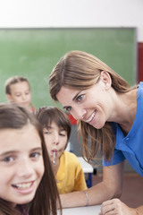 Fototapeta na wymiar Teacher looking at pupil and smiling