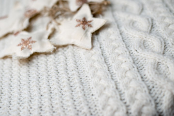 White woolen knitted sweater with star decorations. Winter time