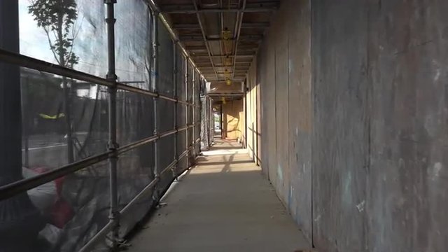 A pedestrian's point of view of walking through a construction frame.