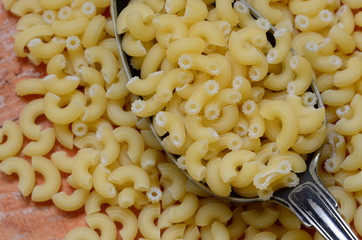 Italian pasta on brown wooden background.
