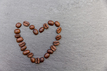 Herz aus Kaffeebohnen auf Schieferplatte