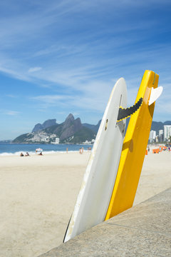 Stand up paddle surfboards line lean against the boardwak at Arpoador at Ipanema Beach, Rio de Janeiro, Brazil