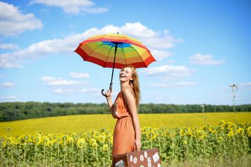 Portrait of beautiful young blond woman holding travel suitcase
