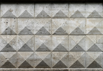 Old ashlar wall made of dolomite rock carved in geometrical pattern