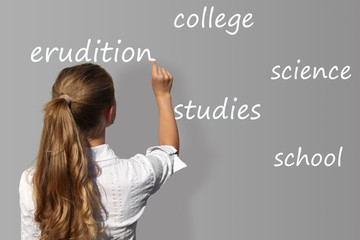 Young girl writes on the blackboard