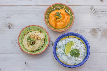 Humus and tzatziki on a wooden table