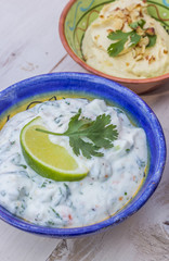 Tzatziki and humus on a wooden table