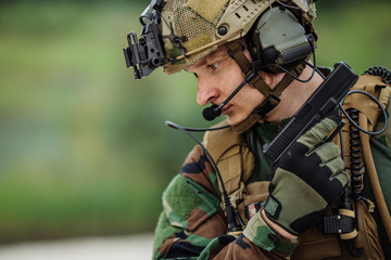 portrait of soldier with canadian camouflage pointing with pisto