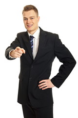 Naklejka premium Smiling young businessman in suit shows on you with his finger