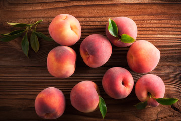 Ripe peaches in basket on wooden background