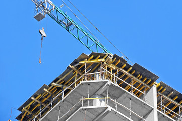 Crane and building construction site against blue sky