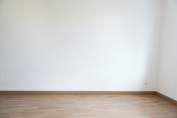 Corner of an empty room in white with parquet floor