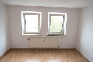 Unfurnished room with two windows, radiator and parquet floor