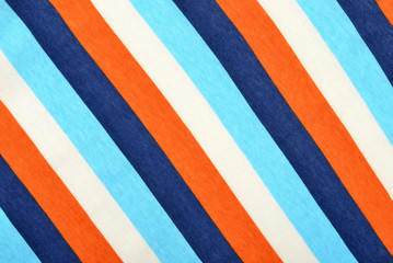 Blue and orange with white striped background. Diagonal stripes pattern on fabric.