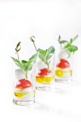 set of canapes in glass with mozarella, tomato and olive oil greece salad