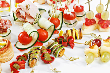 close-up view set of canapes with vegetables, salami, seafood, meat and decoration on whie plate studio isolated