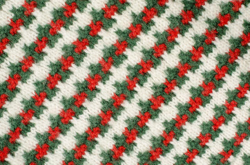 Striped sweater background. Green and red on white wool diagonal stripes pattern on fabric.