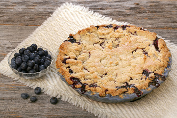 Blueberry pie on rustic wooden table with place mat