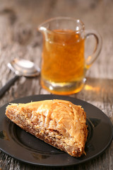 Baklava, delicious pastry dessert made with phyllo dough, nuts, butter and sugar served on a plate with a jar of honey