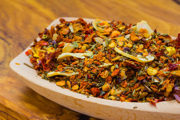 Colored spices for pasta mix on wooden spoon