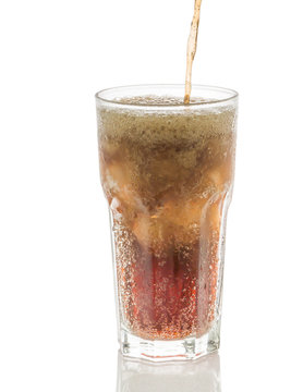 Pouring cola into glass with ice cubes isolated