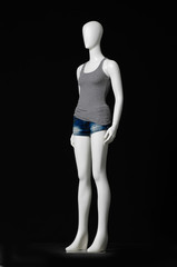 full-length female mannequin in gray dress and shorts on black background


