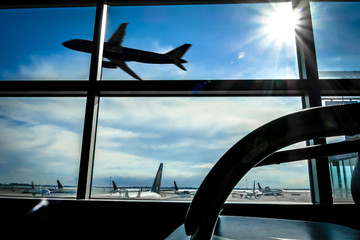 Fototapeta na wymiar Looking at a airplane taking off from the inside of a lounge in the airport