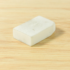 Old pencil eraser on wood board.