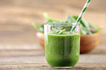 Glass of spinach juice on wooden background