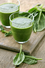 Glasses of spinach juice on wooden table, closeup