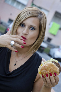 Donna mangia un panino per strada