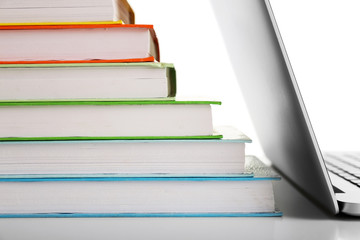 Stack of books with laptop close up