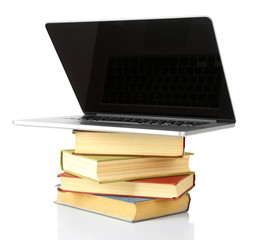 Stack of books with laptop isolated on white