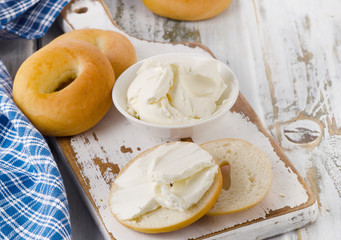Bagels with cream cheese on  wooden table.