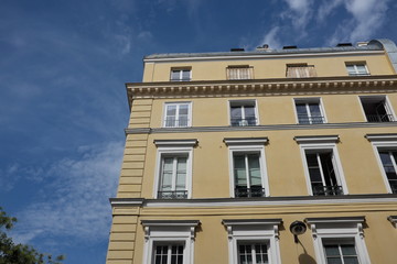 Fototapeta premium Façade d'immeuble ancien avec ciel bleu nuageux.