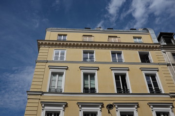 Obraz premium Façade d'immeuble ancien avec ciel bleu nuageux.
