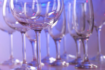 Empty wine glasses on color background
