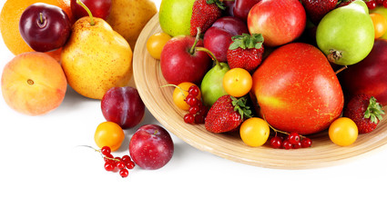 Fototapeta na wymiar Heap of fresh fruits and berries on plate isolated on white