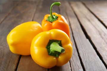 Yellow peppers on rustic wooden table, closeup