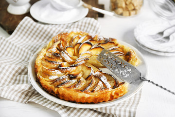 Homemade apple pie on plate, on white wooden table background background